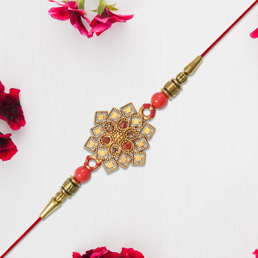 Traditional Golden Floral Rakhi With Intricate Design And Red Beads On Red Thread