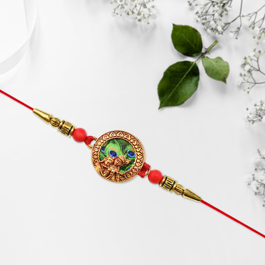 Traditional Krishna Rakhi With Peacock Feather Design And Decorative Beads On Red Thread